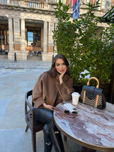 A lady wears a mid-length jacket in winter.